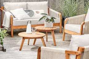 Terrasse mit Gartenmöbeln der BUTLERS-Serie Rope Island, die mit angesagtem Rope Design und Holz zum Eyecatcher avancieren. Dazu viele Grünpflanzen, Windlichter, Vasen und Kissen.