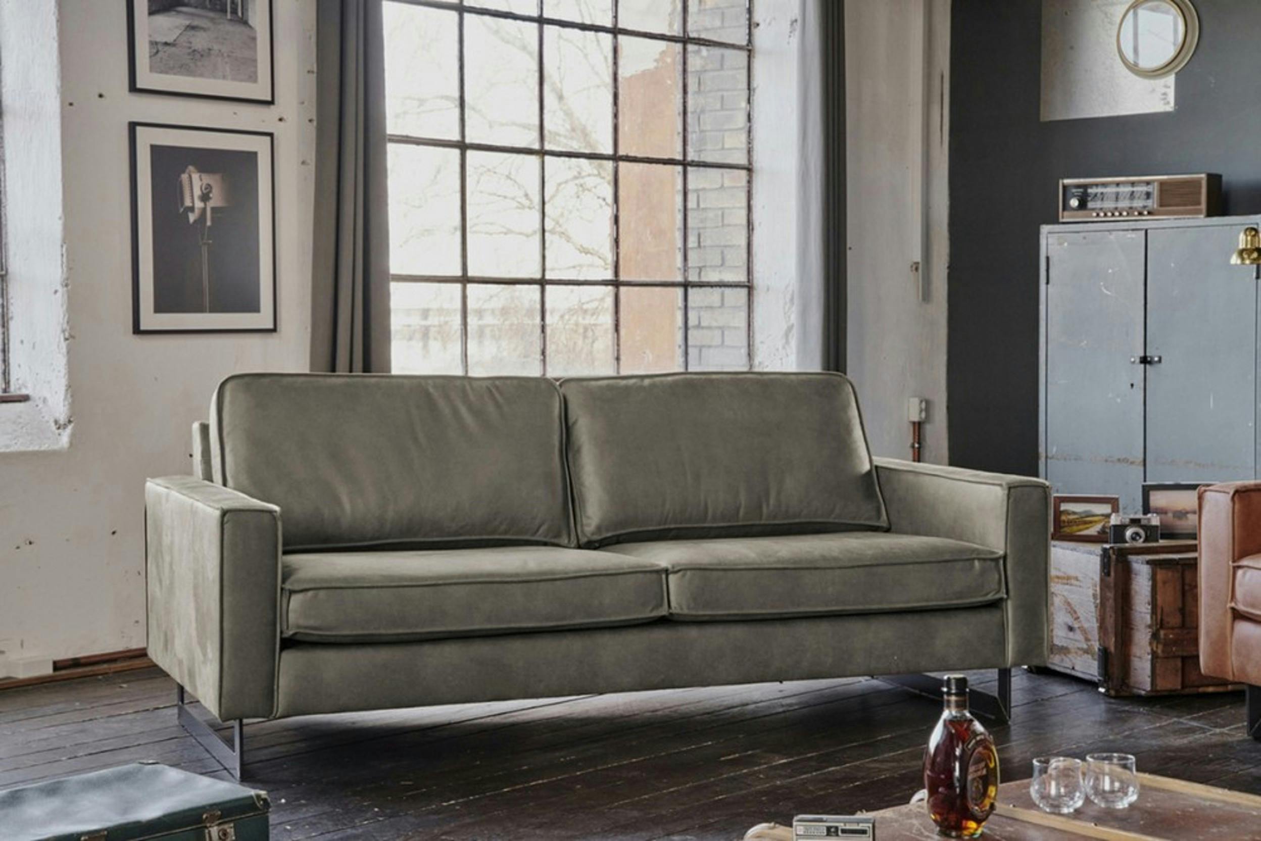 Graues Kunstledersofa in einem Loft im Industrial-Stil