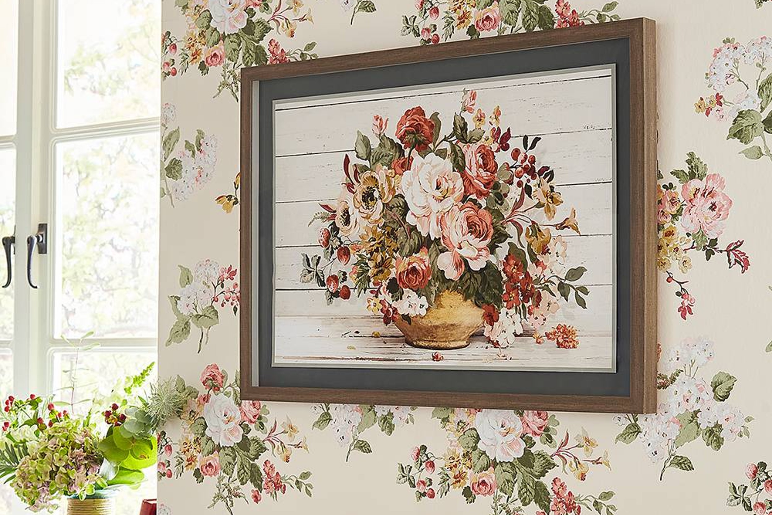 Gerahmtes Bild mit voluminösem Blumenstrauß vor einer Blumentapete