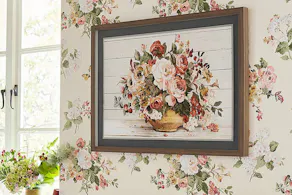 Gerahmtes Bild mit voluminösem Blumenstrauß vor einer Blumentapete