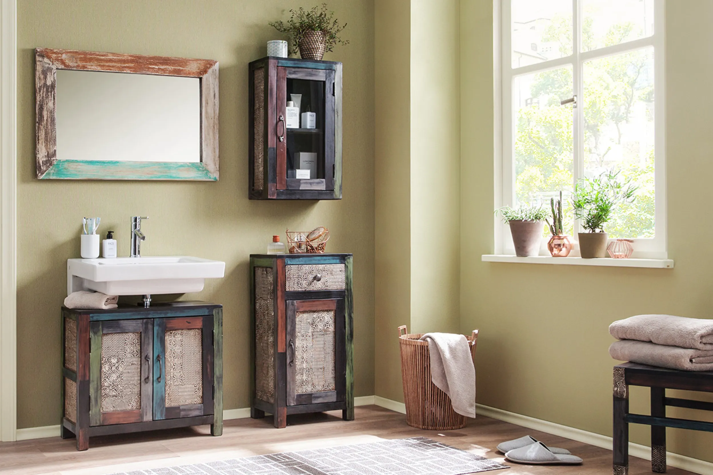 Badezimmer mit lindgrünen Wänden und bunten Holzmöbeln