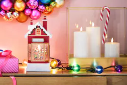 Weihnachtsdeko in pinken Farbtönen mit einem roten Lichterhaus und Laternen mit weißen Kerzen