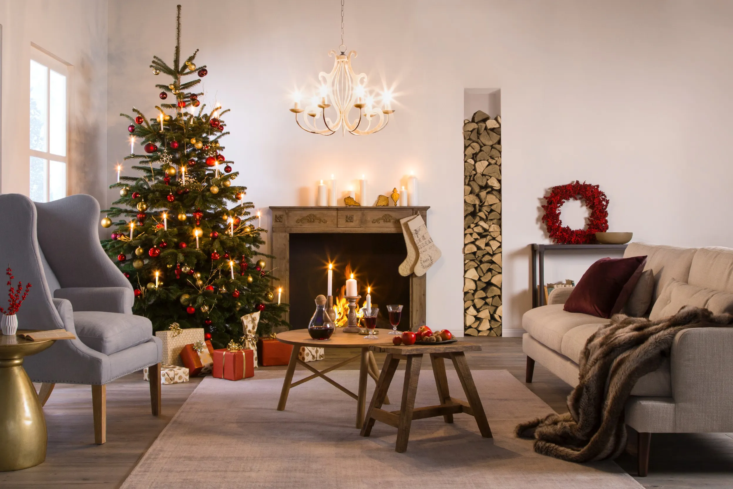Weihnachtliches Wohnzimmer mit Kamin, geschmücktem Weihnachtsbaum und Deko
