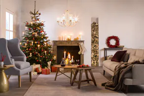 Weihnachtliches Wohnzimmer mit Kamin, geschmücktem Weihnachtsbaum und Deko