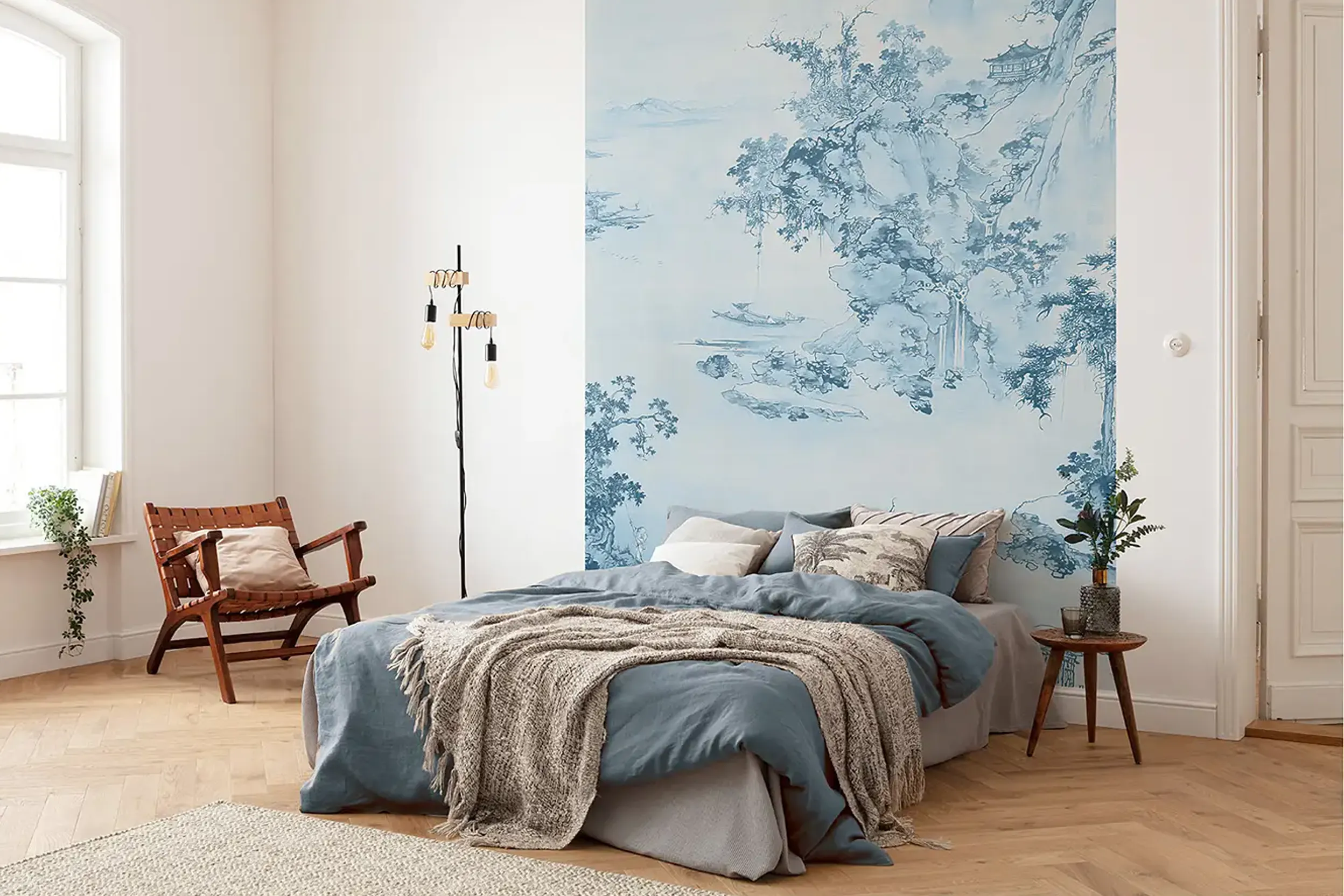 Schlafzimmer mit blauer Motivtapete und Bett mit blauer Bettwäsche