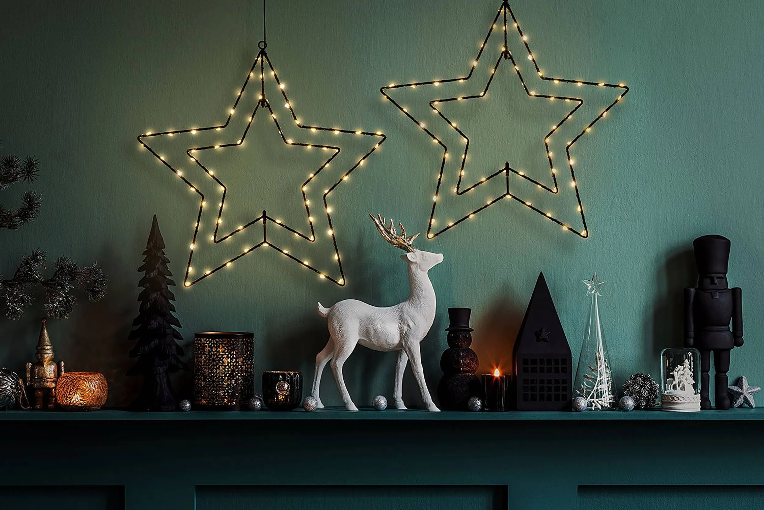 Weihnachtsdekoration mit Figuren, beleuchteten Sternen und Kerzen