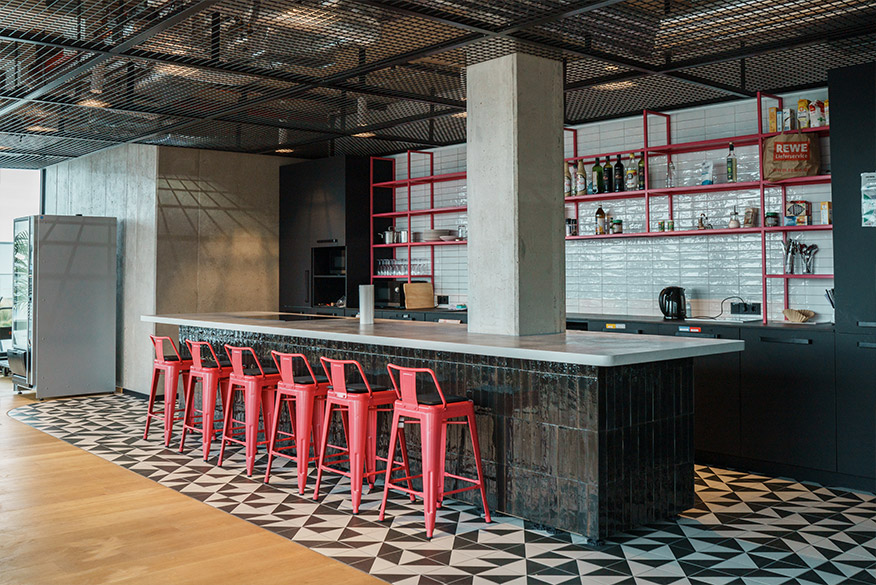 Küche im Loft-Design mit schwarz-weiß gefliestem Boden und pinken Barstühlen als Einrichtungsbeispiel für Bars