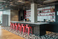 Küche im Loft-Design mit schwarz-weiß gefliestem Boden und pinken Barstühlen als Einrichtungsbeispiel für Bars