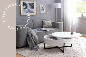 Kleines Wohnzimmer stilvoll und minimalistisch eingerichtet mit grauem 2-Sitzer-Sofa sowie einem kompakten Couchtisch inkl. integriertem Stauraum.