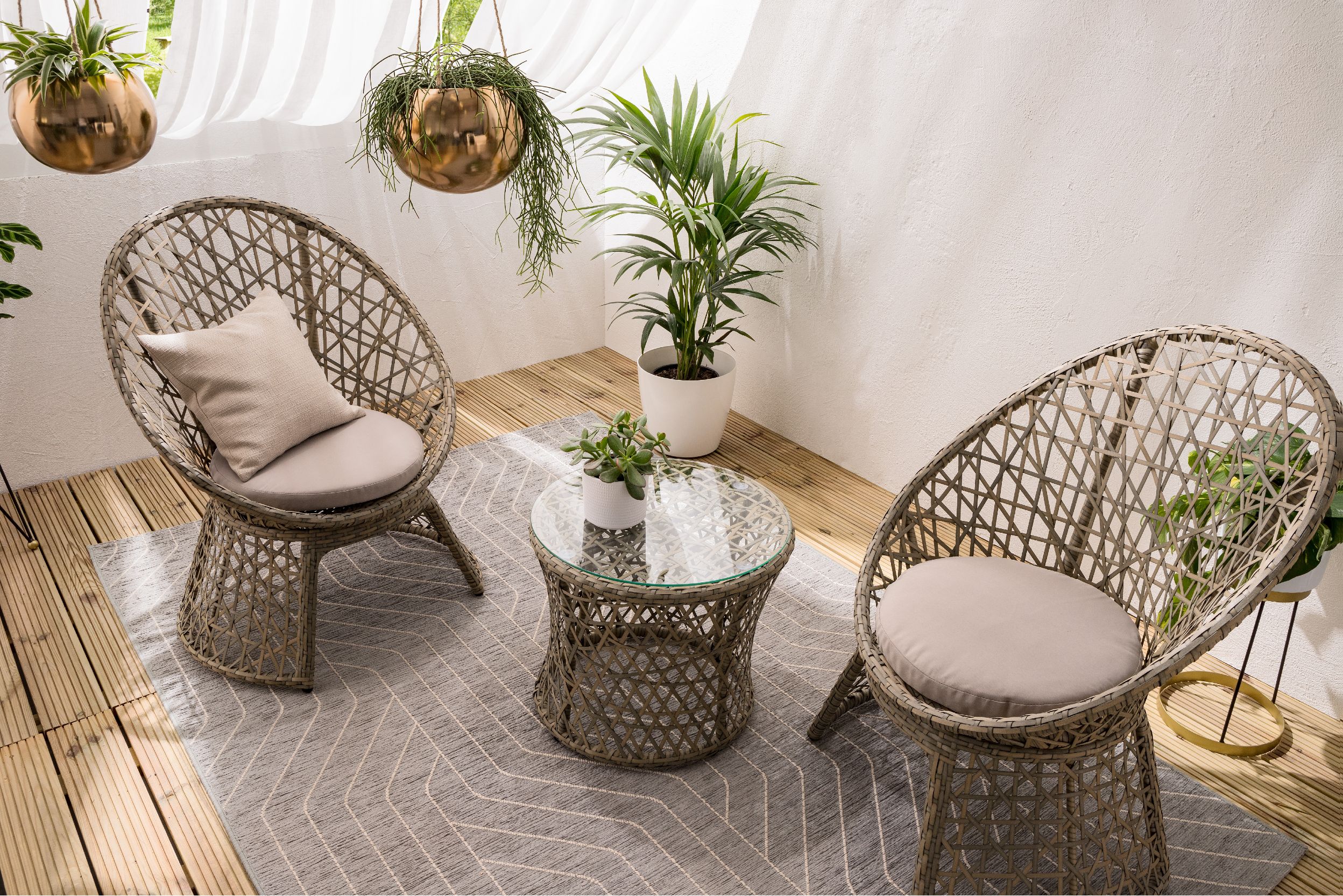 Geflochtene Sessel für draußen auf Outdoor-Teppich