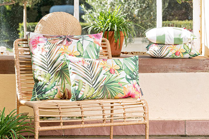 Kussen met jungle-print op een fauteuil van rotan