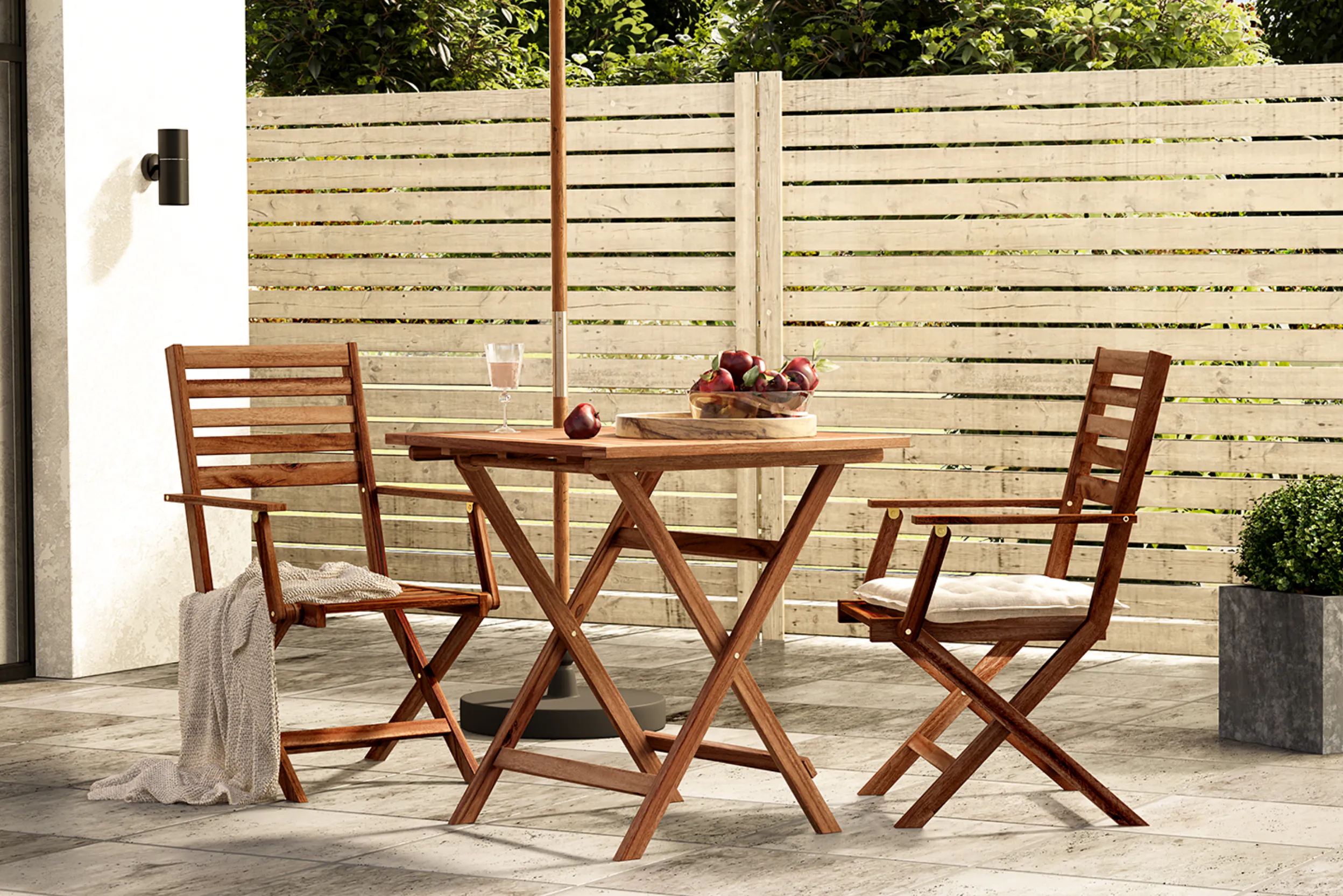 Klapptisch aus Holz mit Klappstühlen auf Terrasse unter Sonnenschirm