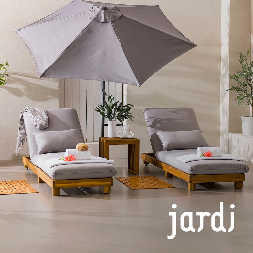 Zwei Sonnenliegen der home24 Exklusivmarke Jardi aus Massivholz mit hellgrauem Polster und passendem Kissen, die zum Relaxen auf der sonnigen Terrasse einladen.