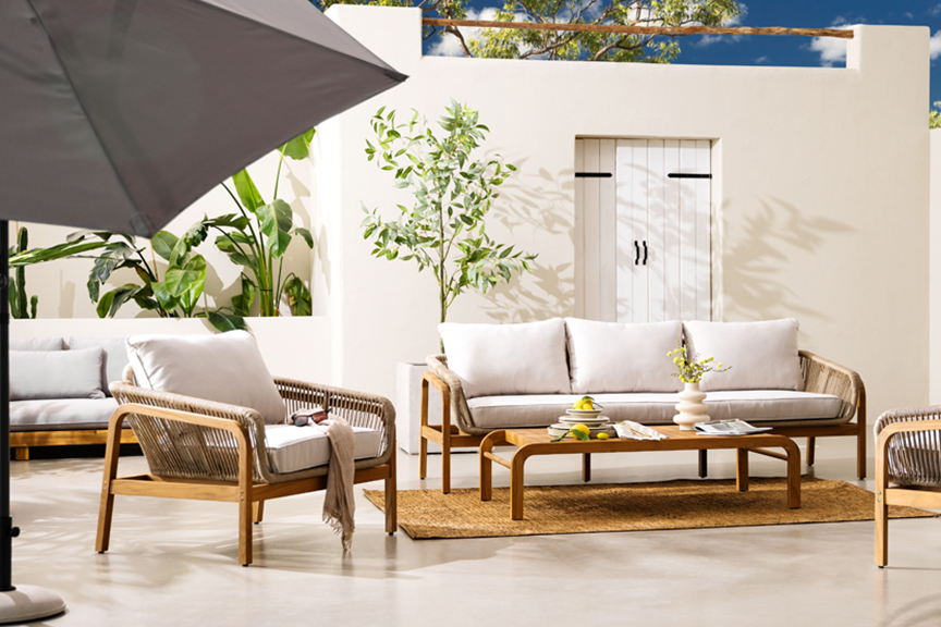 Outdoorlounge Nevis aus Teakholz und Rope Design von der home24 Exklusivmarke Jardi mit vielen Pflanzen, einem natürlichen Juteteppich, hellem Keramikgeschirr sowie weiteren Accessoires.