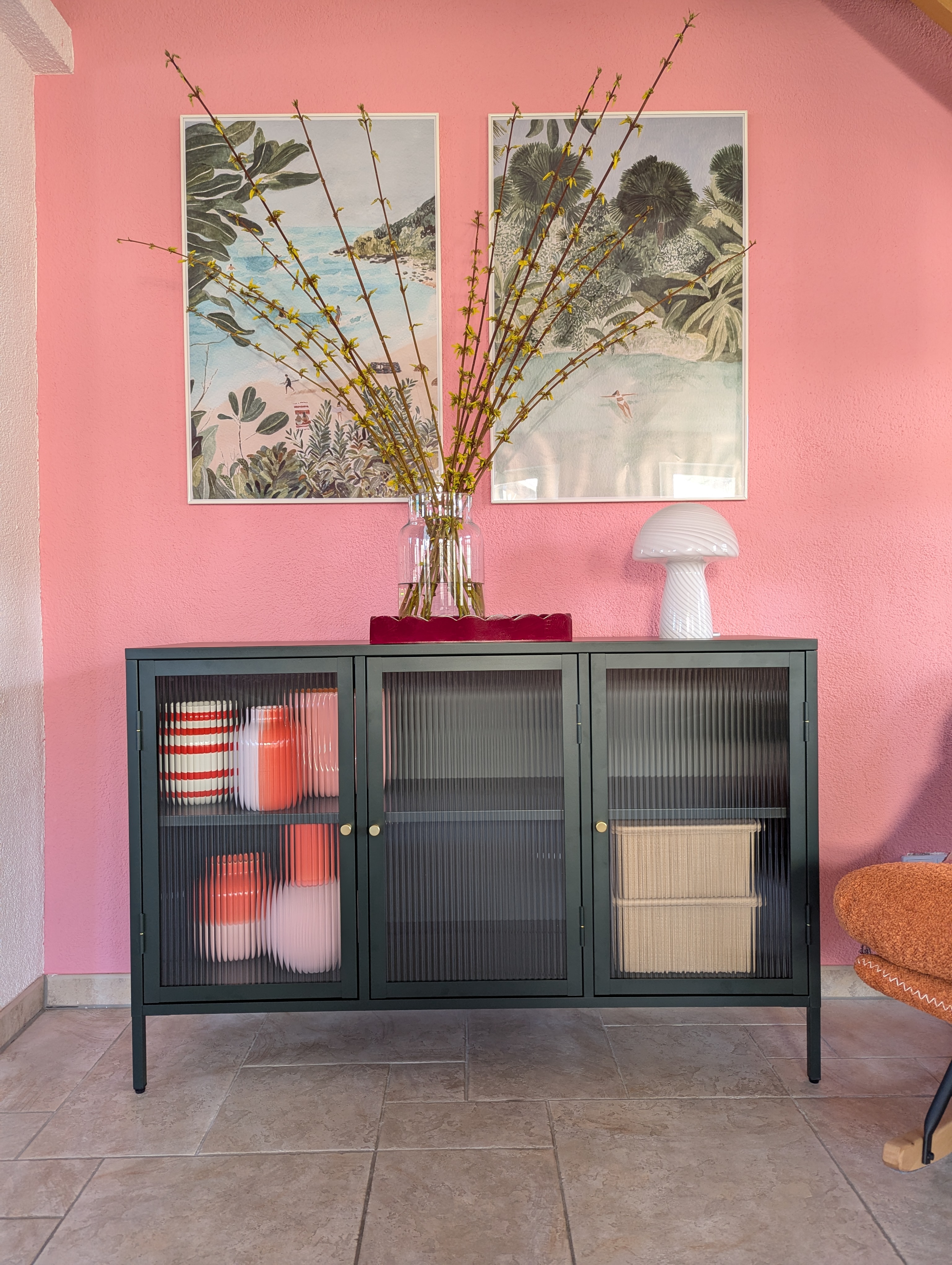 Weiße Tischleuchte Fungi Town auf dunkelgrünem Sideboard vor pinker Wand