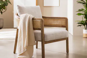 Fauteuil lounge en rotin Maouk de chez home24, avec revêtement blanc.