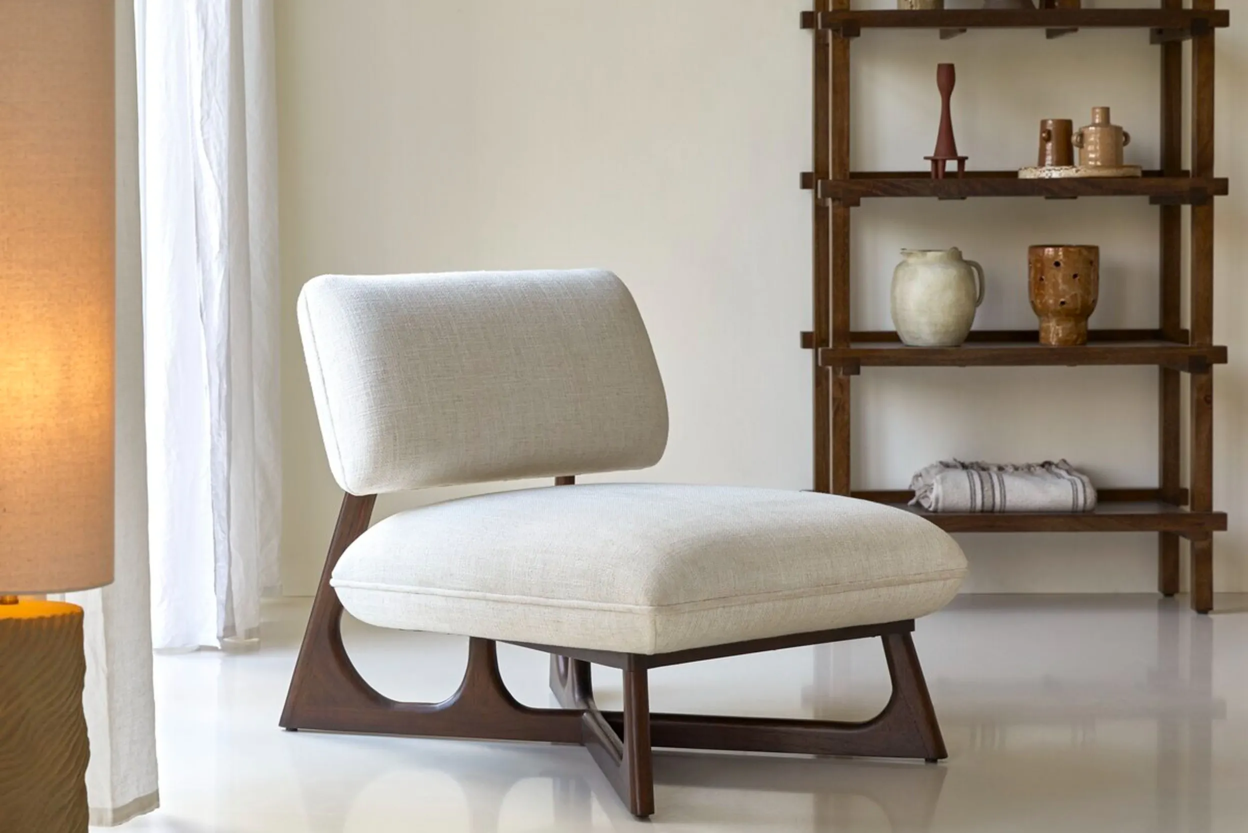 Moderner Loungesessel mit dicken Polstern und dunklem Holzgestell