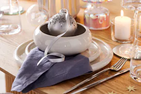 Silber-blaue Tischdeko von BUTLERS für eine weihnachtlich gedeckte Festtagstafel.