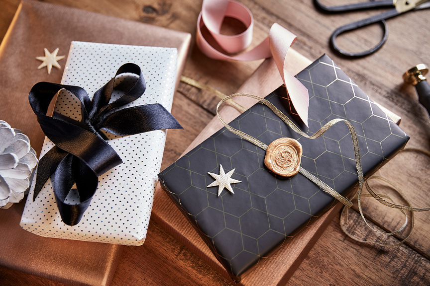 Liebevoll verpackte Weihnachtsgeschenke auf einem Holztisch.