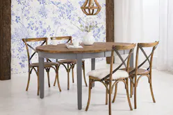 Ovaler Massivholztisch mit grauen Tischbeinen und rustikalen Holzstühlen im Country-Style.