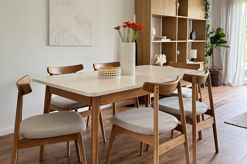 Massivholztisch Lindholm mit weißer Tischplatte und passenden Holzstühlen gestylt.