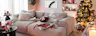 Weihnachtlich gestyltes Wohnzimmer mit einem Big-Sofa als loungiges Herzstück des Raumes, dazu verspielte Dekorationen in Rot und Rosa mit süßen Candy-Motiven.
