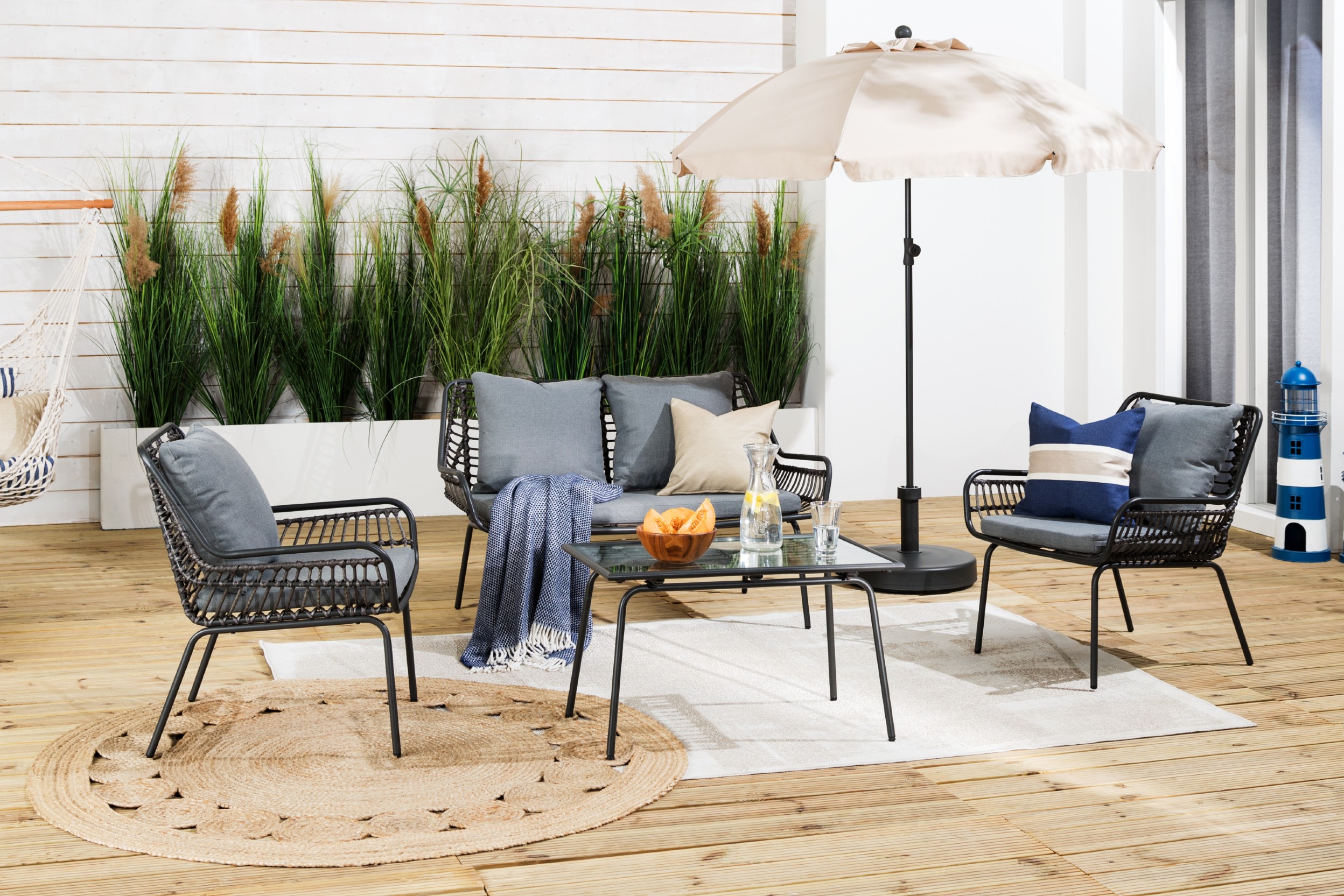 Maritime Terrasse mit Jute-Optik-Teppich und hellem Outdoor-Teppich.