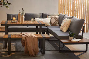 Ensemble de jardin avec effets lamelles et de nombreux coussins ; à côté, un autre ensemble de jardin avec la table mise.