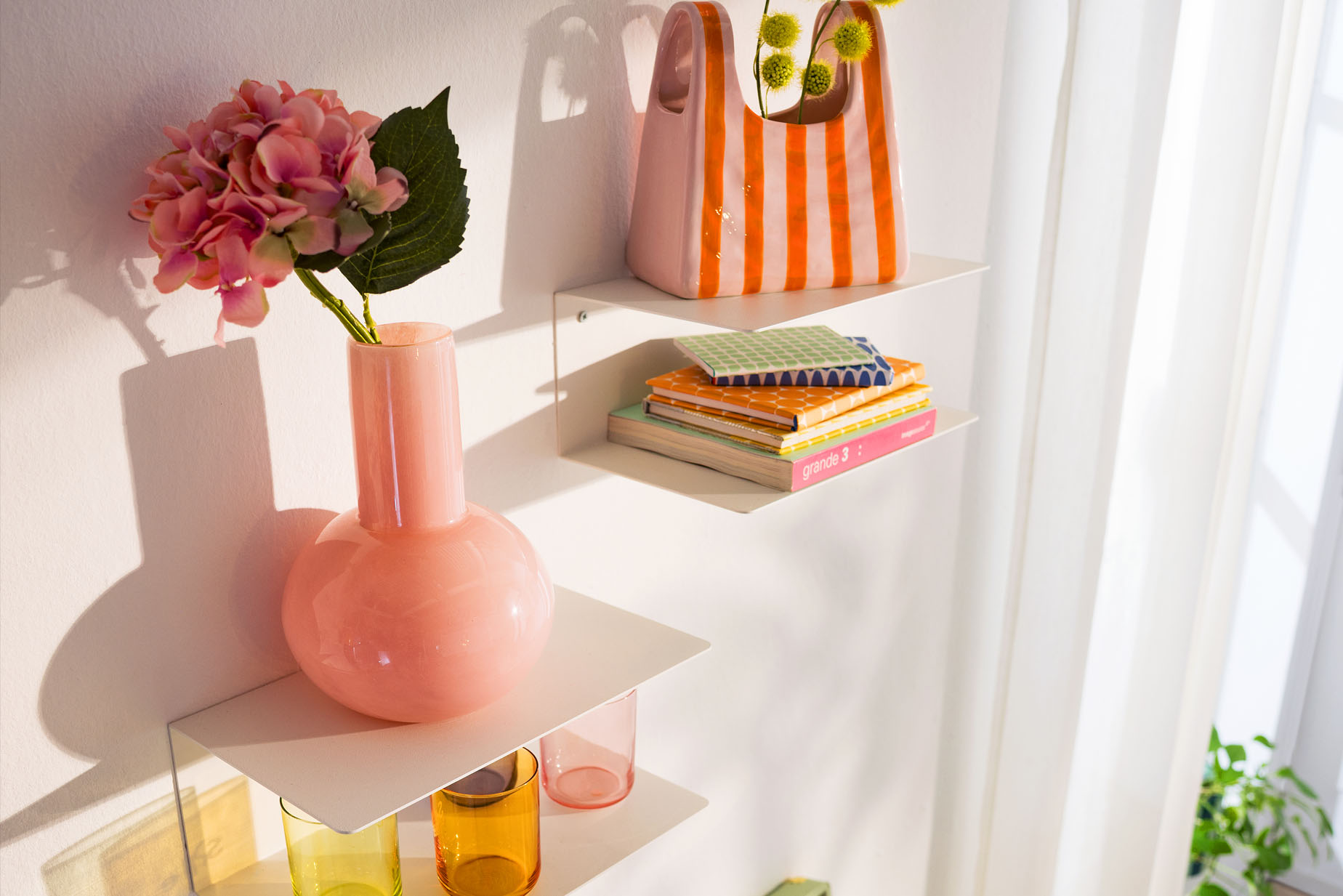 Bunte Blumen und Vasen auf schicken Wandregalen im Esszimmer.