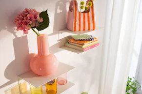 Bunte Blumen und Vasen auf schicken Wandregalen im Esszimmer.