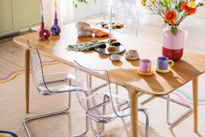 Frühlingsbunt gedeckter Ostertisch in einem skandinavisch eingerichteten Esszimmer.