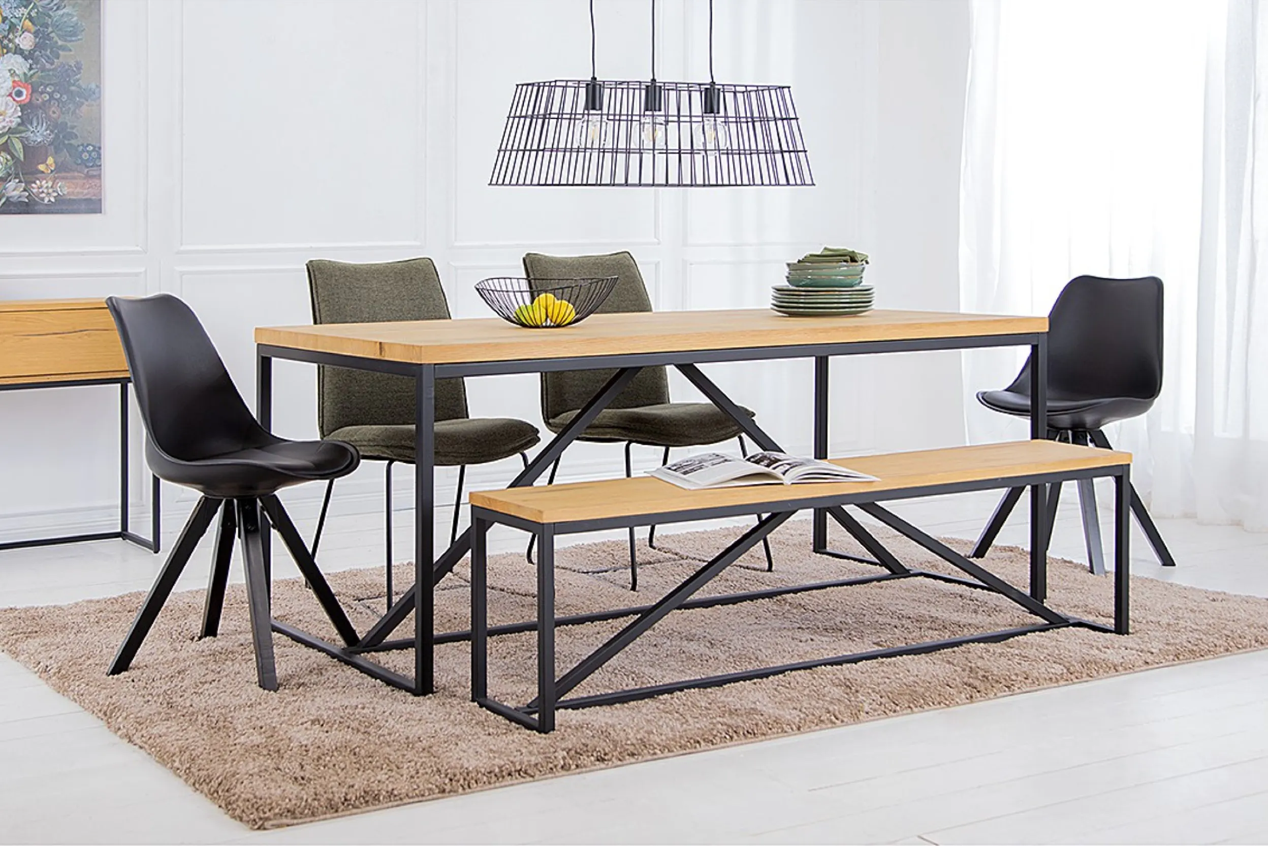 Esstisch mit Bank und vier Stühlen, darüber eine schwarze Pendelleuchte im Industrial-Design