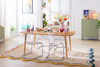 Frühlingsbunt gedeckter Tisch in einem skandinavisch eingerichteten Esszimmer.