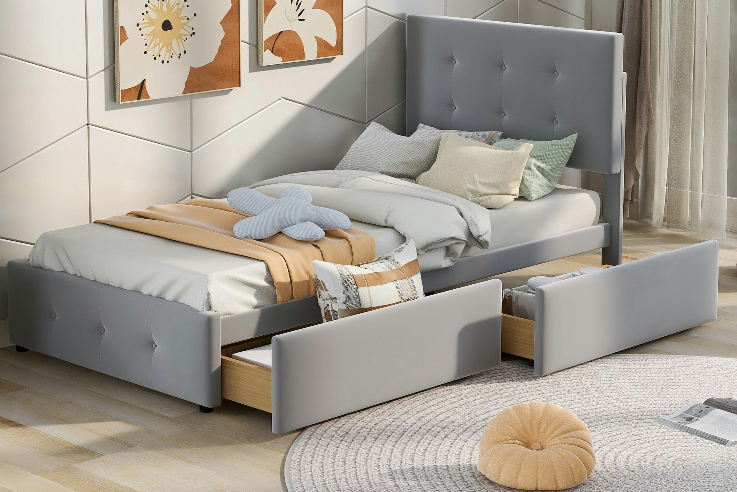 Schmales hellgraues Polsterbett mit zwei halb ausgezogenen Schubladen