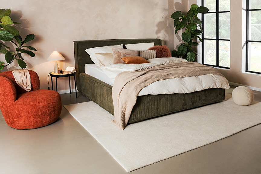 Schlafzimmer mit Cordbett, Holzmöbeln und weiteren Trendmöbeln vom Polsterbett mit Stauraum bis hin zum Curvy Chair.