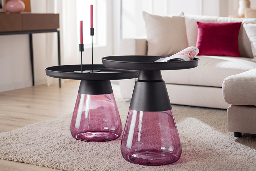 Couchtisch-Set mit einem Fuß aus violett getöntem Glas auf einem strukturierten Wohnzimmerteppich