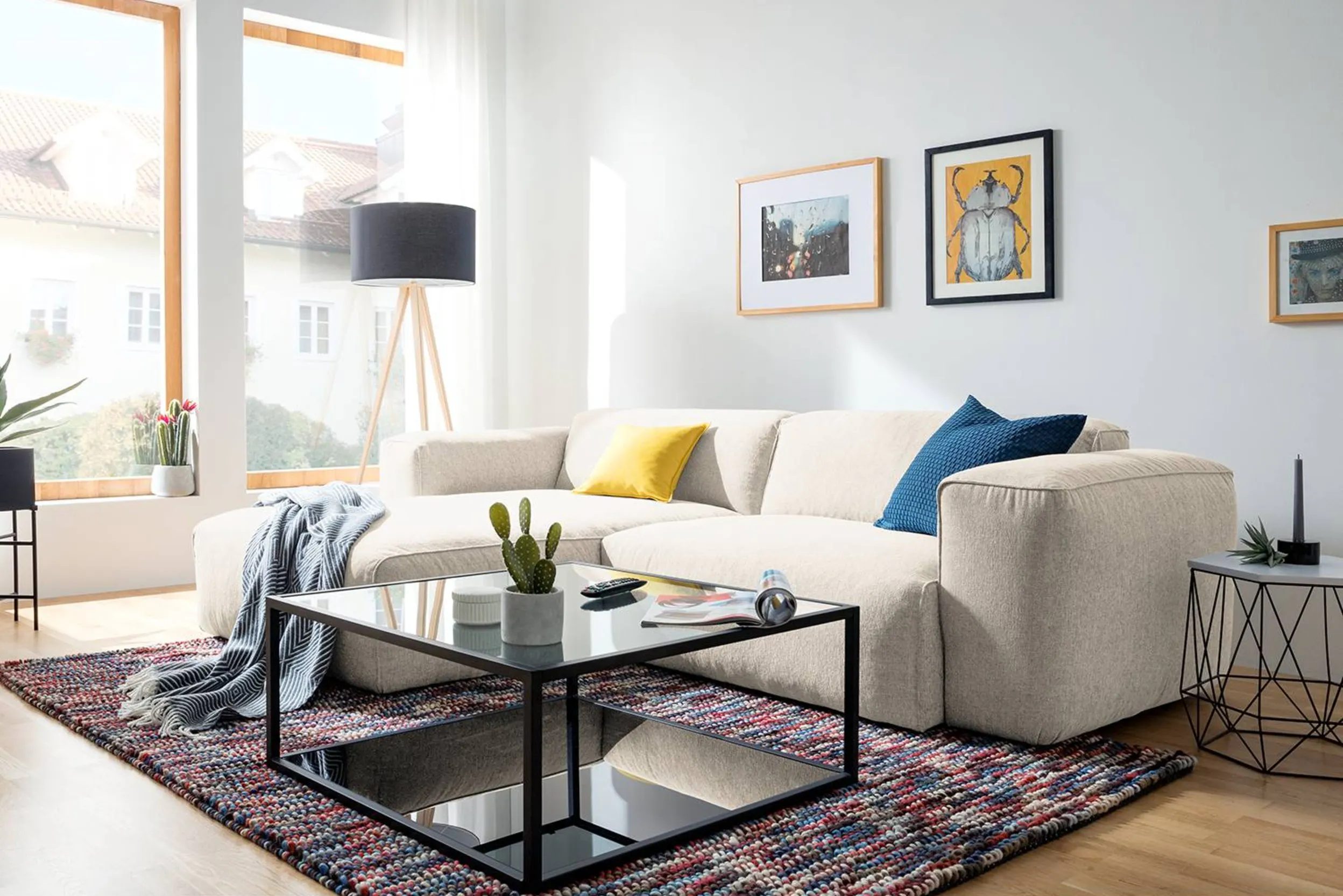 Beiges Ecksofa mit langem Schenkel an der Wand und Recamiere zur Fensterfront