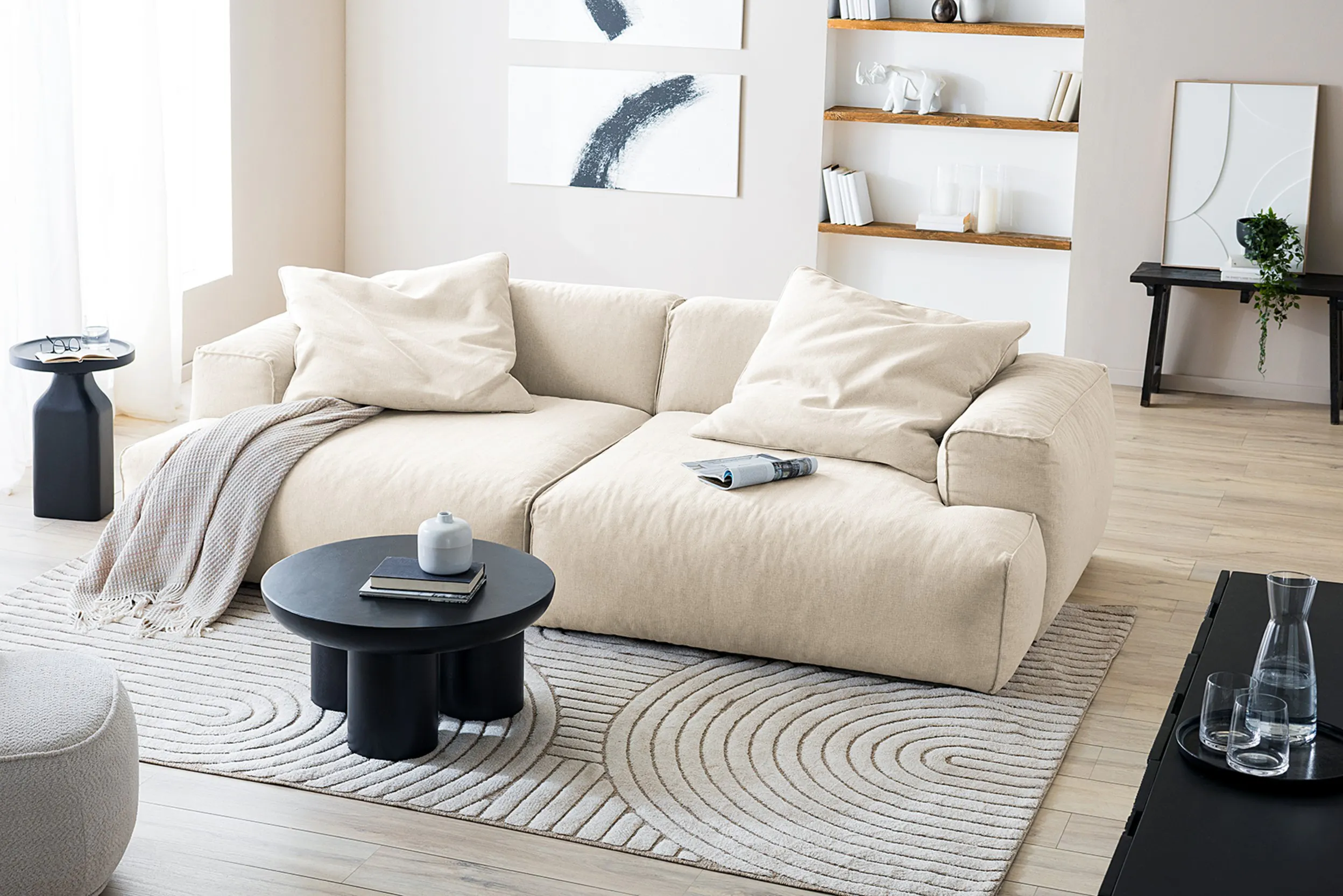 Freistehendes beiges Bigsofa mit Regal dahinter