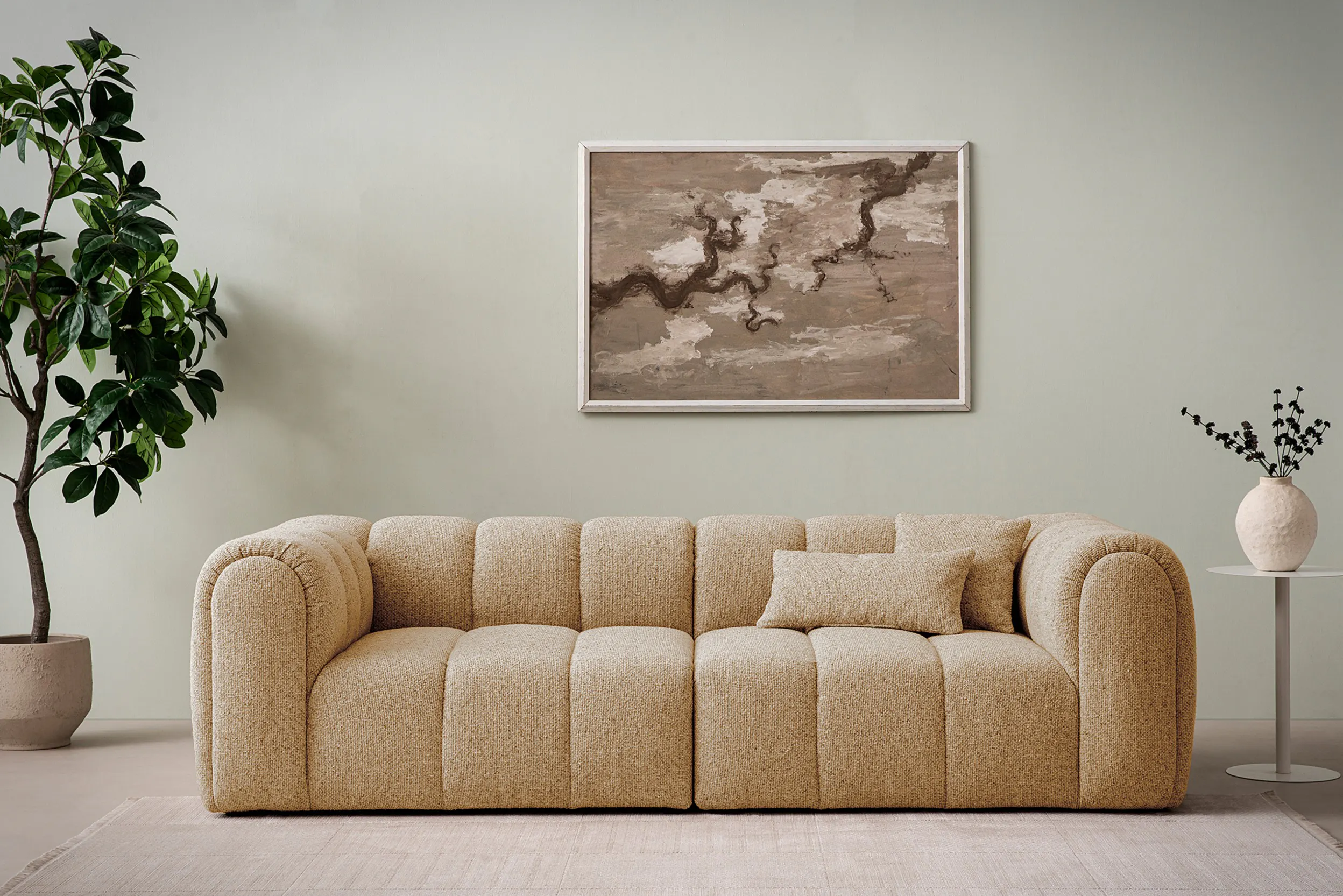 Ein leicht von der Wand abgerücktes beiges Sofa
