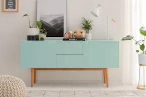 Mint-Grünes Sideboard in Skandi-Stil mit Holzdeko, Pflanzen und Wandbild