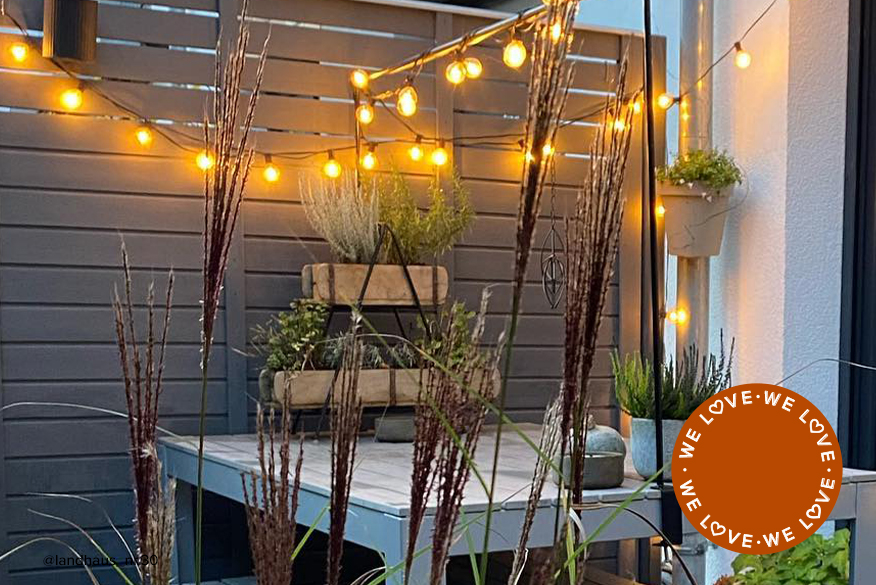 Terrasse mit robusten Outdoor-Möbeln, winterharten Pflanzen und Lichterkette als Beleuchtung – fertig hergerichtet für die Wintermonate im Freien, daneben eine Lichterkette im Detail