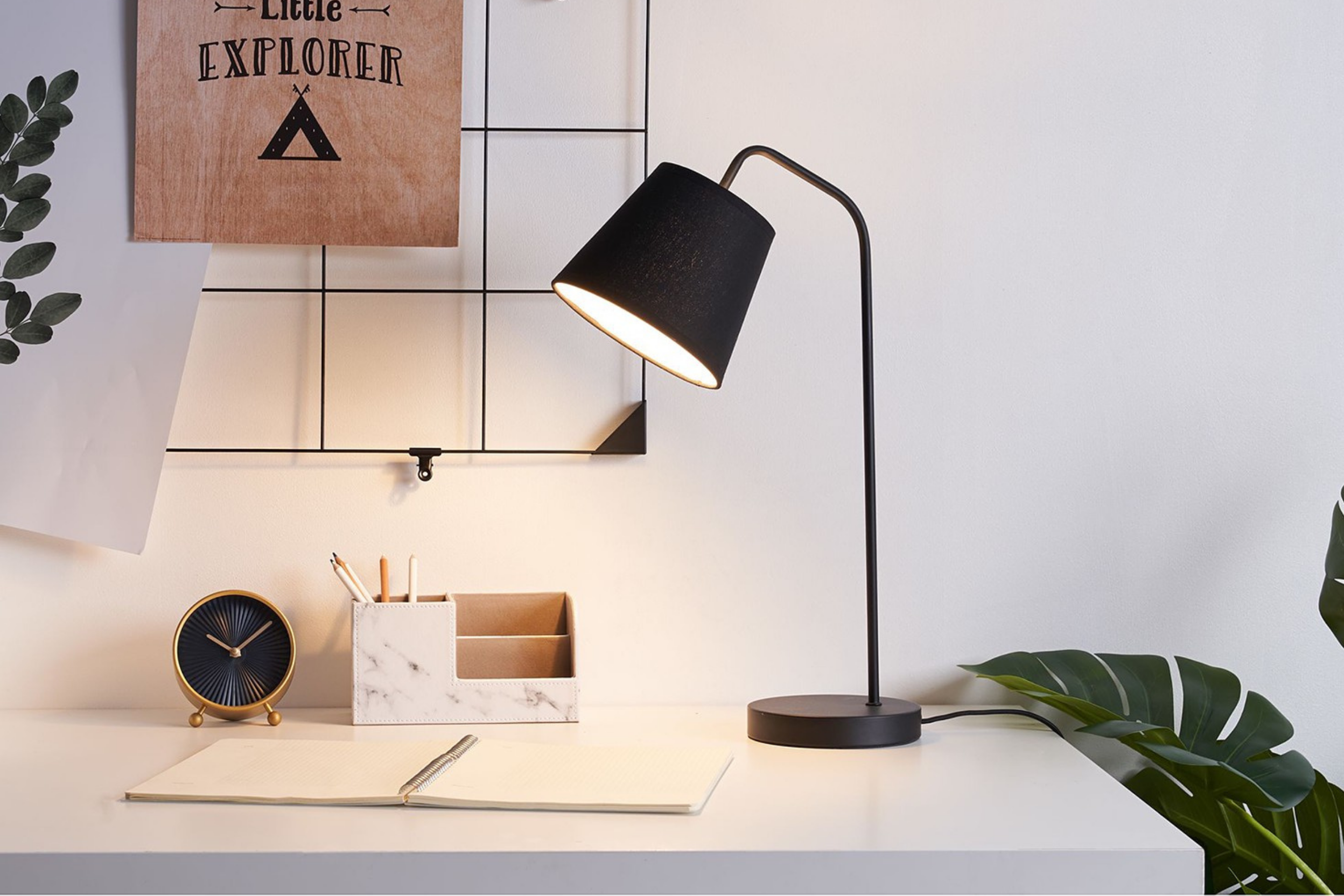 Schwarze Tischlampe auf weißem Schreibtisch