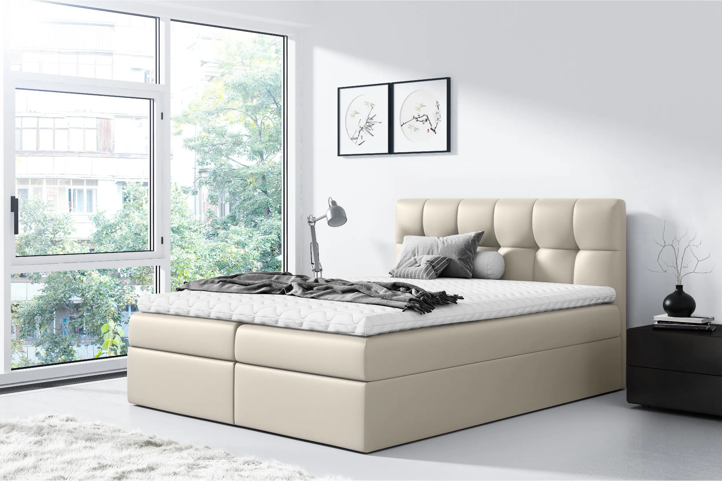 Boxspringbett aus cremeweißem Kunstleder in einem minimalistisch eingerichteten Zimmer