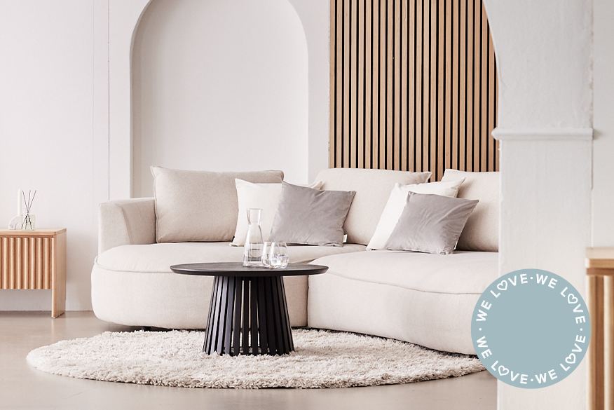 Wohnzimmer in Neutrals zeigt das cremefarbene Sofa Buckley mit gerundetem Polster und rundem Couchtisch aus schwarzem Holz; daneben ebenfalls Sofa Buckley in Beige gestylt im Wohnzimmer von @jasmin_laabs, deren brauner Hund eingerllt vor dem Sofa auf einem beigen Teppich schläft.