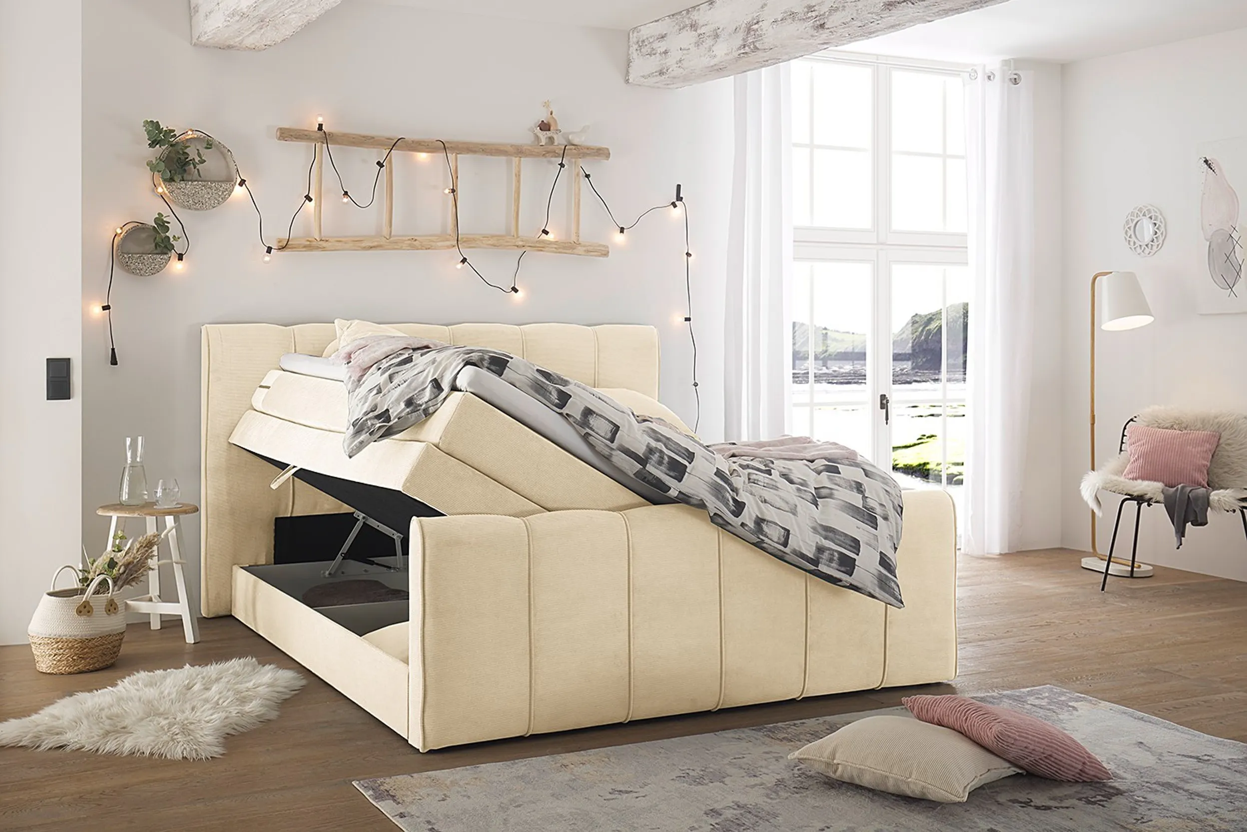 Beige-gelbes Boxspringbett mit offenem Bettkasten in einem jugendlich wirkenden Schlafzimmer