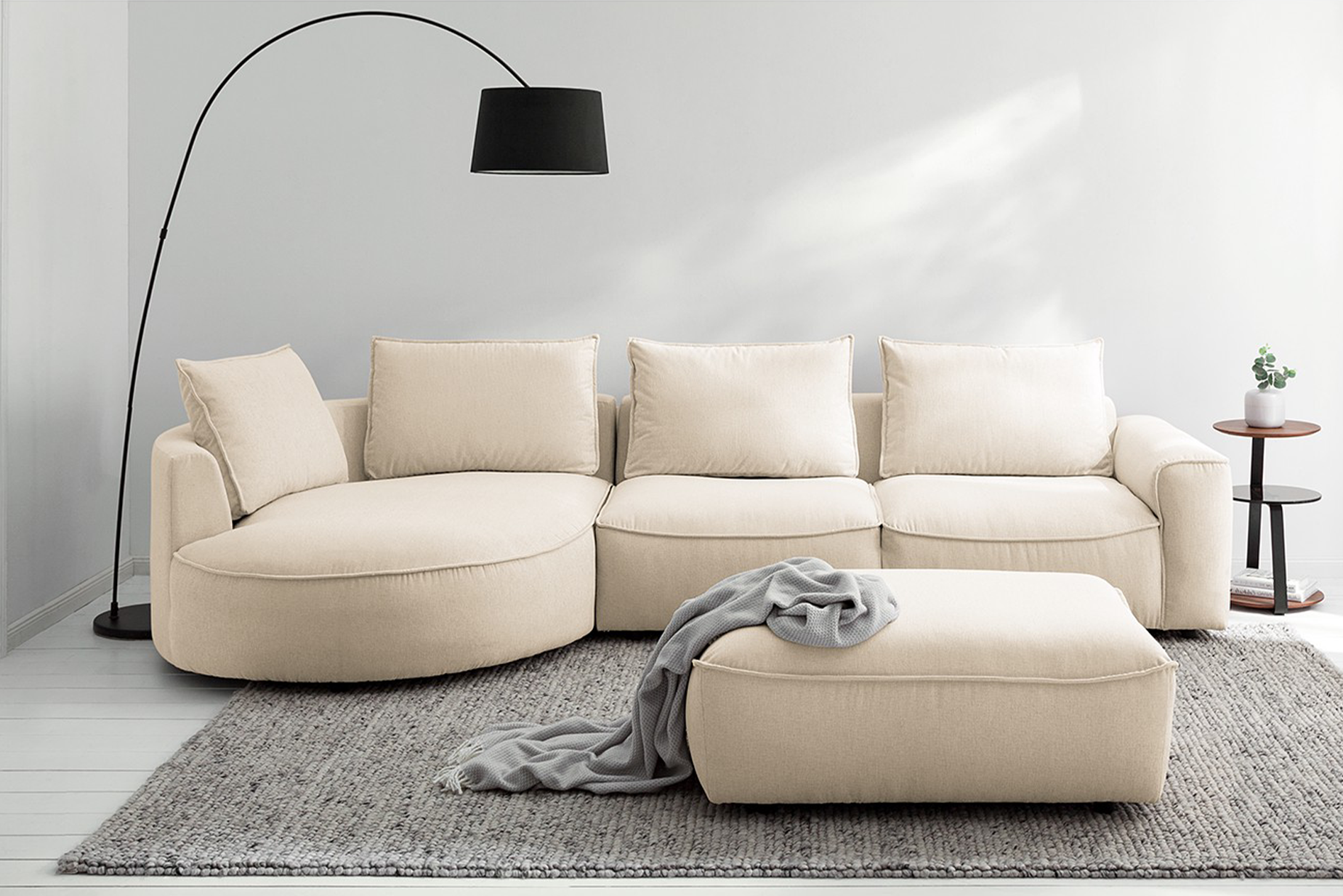 Grand canapé de la série Buckley de notre marque exclusive Studio Copenhagen, formes arrondies et revêtement en tissu beige.