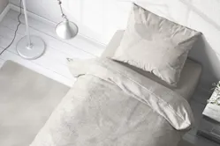 Einzelbett in Grau, mit hochwertiger Bettwäsche und Teppich in Hellgrau