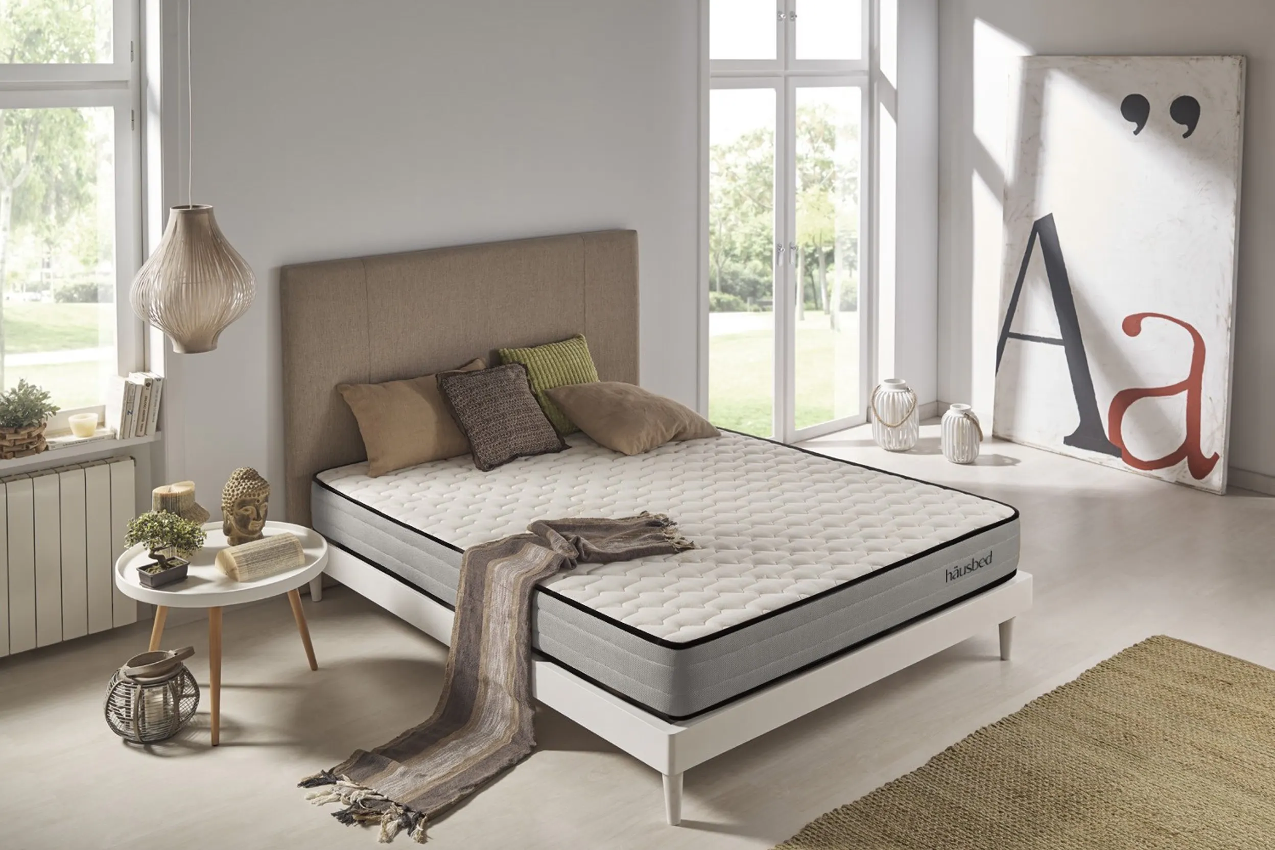 Großes Schlafzimmer mit Bild, Laternen, Nachttisch und einem Polsterbett mit Matratze