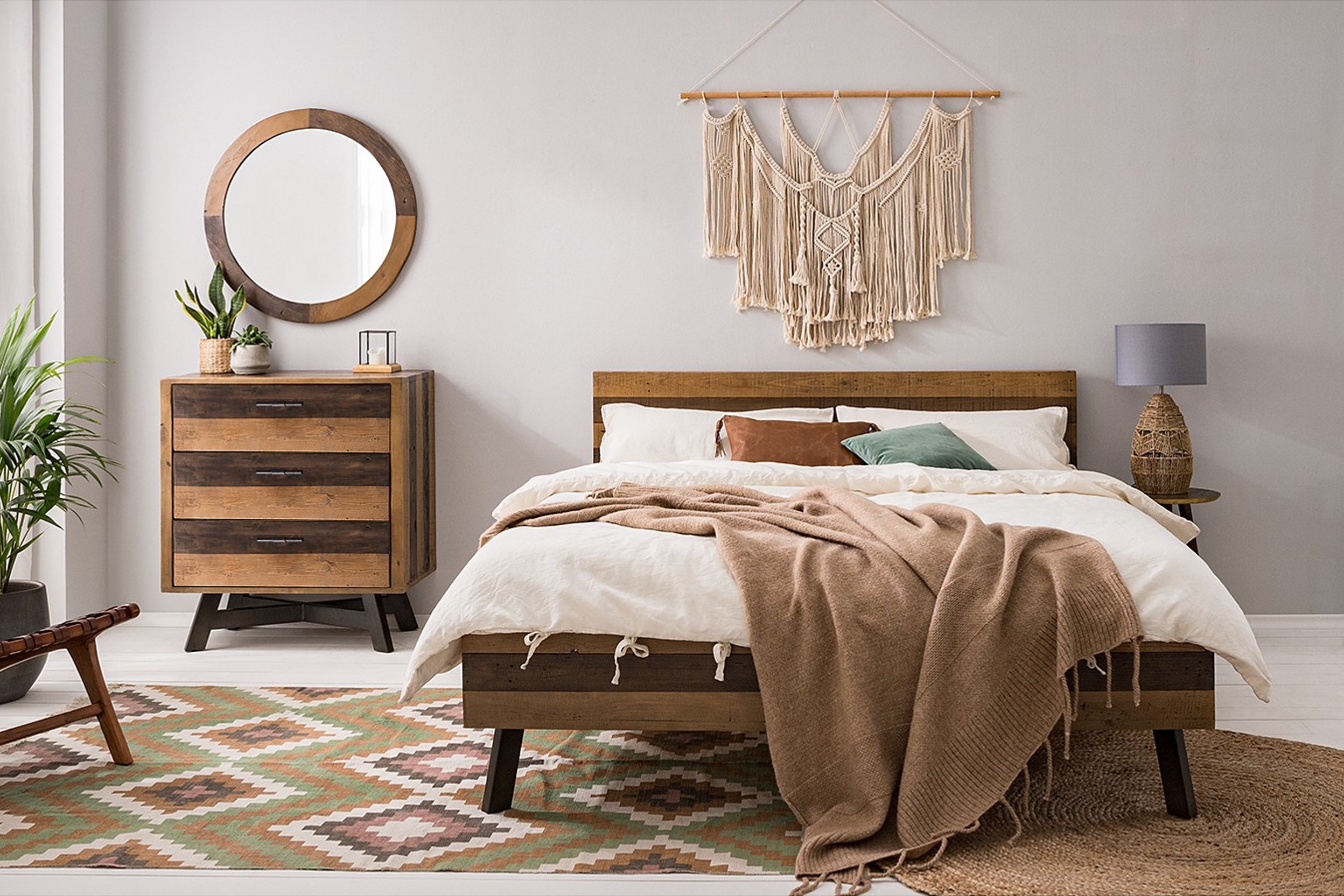 Bettgestell aus Holz kombiniert mit Kommode aus Holz und Deko aus Naturmaterialien