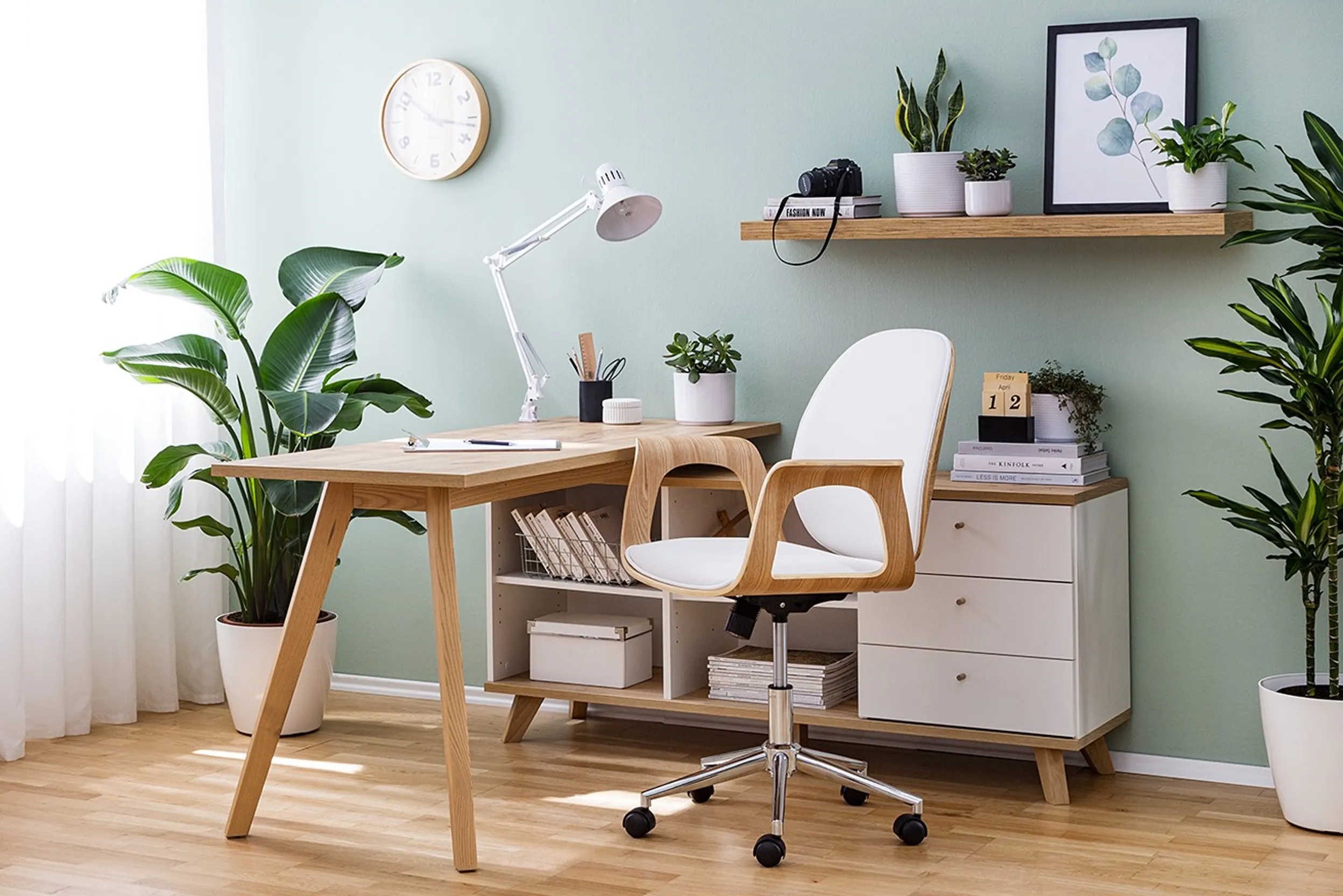 Moderne Arbeitsecke aus hellem Holz mit vielen grünen Pflanzen